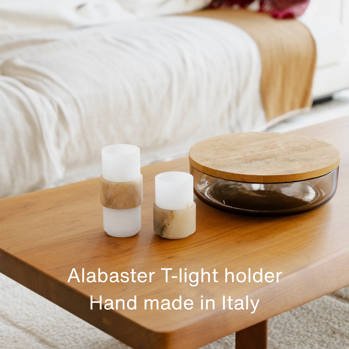 Alabaster waxinelichthouders set van Stan Editions op een salontafel. Alabaster tealight holder set by Stan Editions on a coffee table. Ensemble de photophores en albatre de Stan Editions sur une table basse.